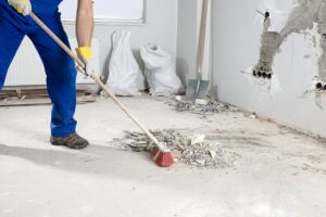 Construction worker cleaning floor during a building project